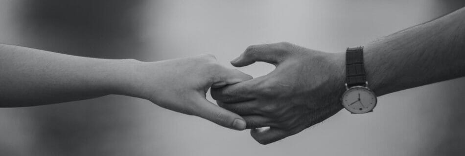 monochrome photo of couple holding hands