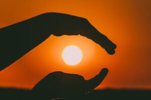 silhouette of person s hands during sunset