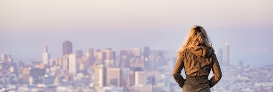 woman on rock platform viewing city