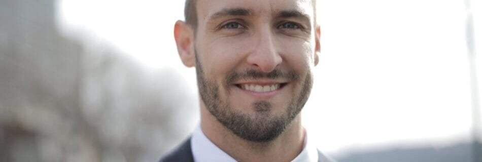 man in black suit jacket smiling