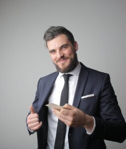 man in black suit holding a calling card