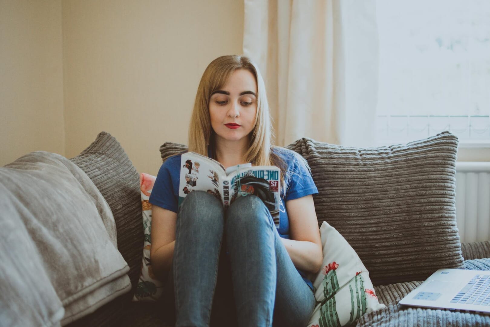 woman sitting on couch while reading a book